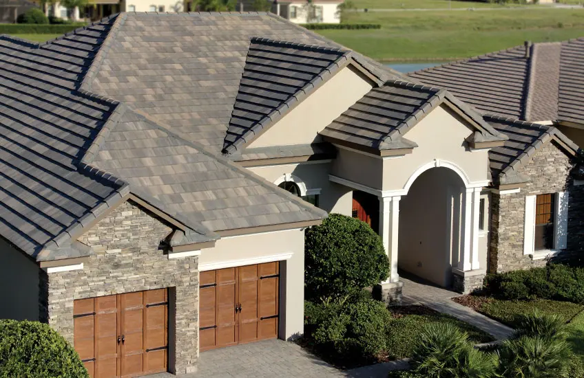 A house with two garage doors and a roof that has been covered in shingles.